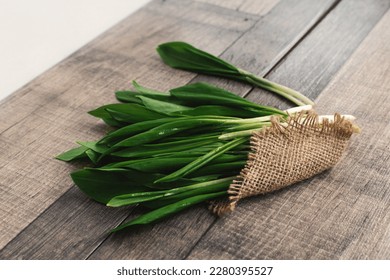 Wild garlic (Allium ursinum). A  bunch of fresh wild garlic ( ramson) on a table. Toned image.