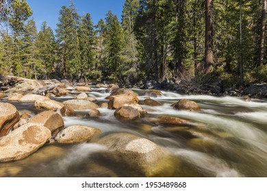 Wild Merced river with turquoise water and many boulders in Yosemite National Park. Long exposure. California, USA