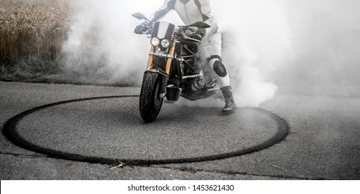 
wild motorcyclist lets the tires spin during a burnout and makes a donut