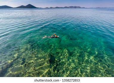 Wild Swim Woman In Sleeveless Wetsuit In Crystal Clear Water