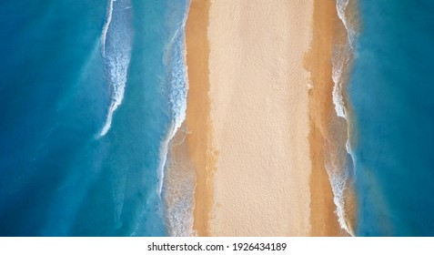 Wild tropical beach and clean sand. Waves crashing on the shore, aerial view.