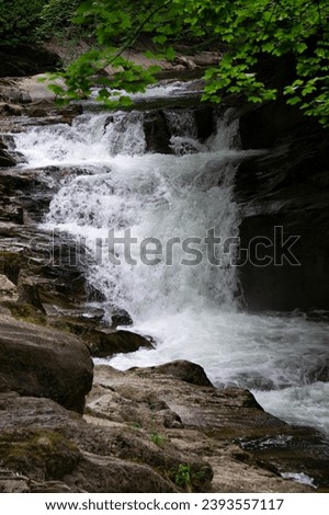 Wild water waterfall between large rocks in the Selva de Irati natural park, Navarrese Pyrenees. Cube waterfall. 