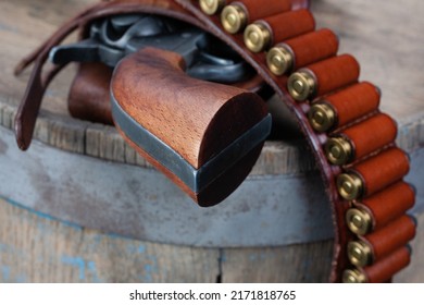 Wild west gun with belt, holster and ammunition on wooden table