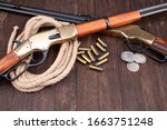 Wild west guns - lever-action repeating rifles with ammunition on wooden table