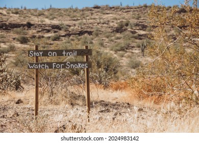 The Wild West. Western Old City In Phoenix, Arizona, USA. Gold Rush City. Old Arizona. A ‘Stay On Trail Watch For Snakes’ Sign In The Desert. Wooden Sign With An Inscription. 