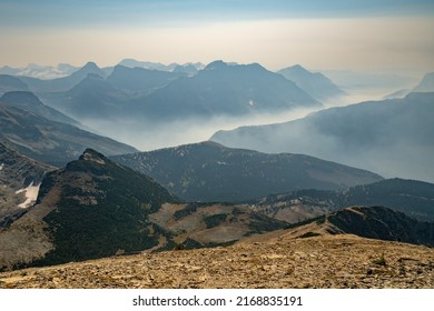Wildfire smoke fills up valley in vast mountains of Glacier National Park, Montana, USA on a hot dry day of summer. Climate change impact. Global warming.  - Shutterstock ID 2168835191