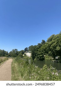 A wildflower lined path along the River Lea on a summer day 