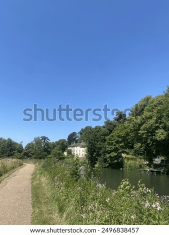 A wildflower lined path along the River Lea on a summer day 