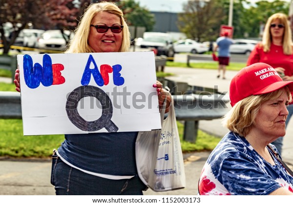 WILKES-BARRE, PA - AUGUST 2, 2018: A woman holds a "We Are Q" sign while in line to attend the "Make America Great Again" rally held at the Mohegan Sun Arena. "Q" stands for QAnon, a conspiracy group.