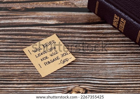 I will never leave you nor will I forsake you-God, handwritten verse on note with holy bible on wooden table. Jesus Christ's promise, love, and care, biblical concept.