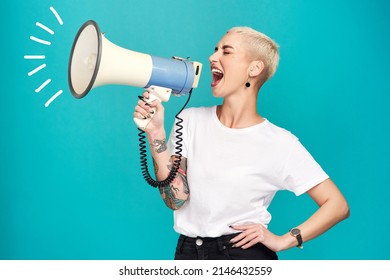 I will not be silenced. Studio shot of a young woman using a megaphone against a turquoise background.