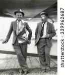 Will Rogers and Wiley Post before their ill-fated flying exploration of Alaska. The plane behind them was an unstable combination of a Lockheed Orion fuselage with wings from a different Lockheed airc