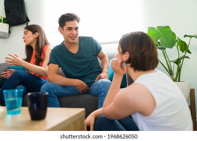 Will You Go Out On A Date With Me? Attractive Young Man Talking With A Young Woman And Flirting During A Hang Out With College Friends At Home