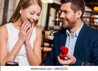 Will You Marry Me? Handsome Young Man Making A Proposal While Giving An Engagement Ring To His Girlfriend In Restaurant 