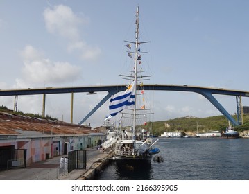 Willemstad, Curacao - June 9, 2022: Capitan Miranda ROU 20 three-masted schooner tall ship on display at Annabaai, Willemstad skyline in the background during the Velas LatinoAmerica 2022 festival