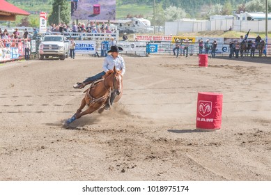 WILLIAMS LAKE, BRITISH COLUMBIA, CANADA - JULY 2, 2016:  Cowgirl And Horse Come Around The Second Barrel At A Barrel Racing Event During The 90th Williams Lake Stampede