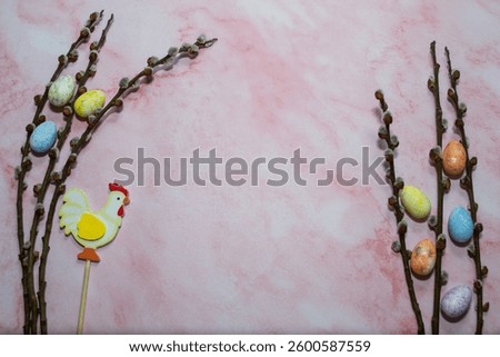 Willow branches with Easter eggs on a light pink background