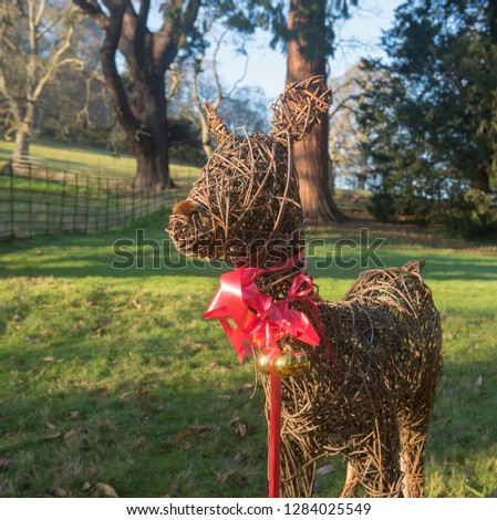 Willow Deer with Christmas Decorations Bathed in Winter Sunshine in a Park in Rural Devon, England, UK