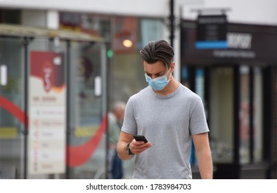 Wiltshire UK. Jul 26 2020. A Young Man In The Street Looks At His Smart Phone. People Living In England And Wales Are Being Urged To Download The Government's Official Contact Tracing App For Covid-19