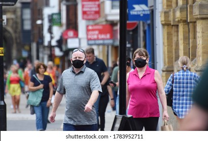 Wiltshire, UK. July 26 2020. An Overweight Couple Wear Face Masks In A Town Centre While Out Shopping On The First Weekend That Wearing Face Coverings In Shops Becomes Law In England. 