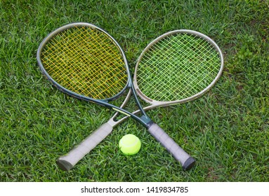 Wimbledon Sign, Two Tennis Rackets With A Ball On Grass