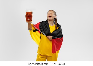 Win. Studio shot of young emotional girl with german national flag supports favorite team isolated over white vackground. Soccer fans emotions, competition, sport, championship concept.