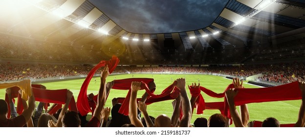 Win, victory of favourite team. Back view of football, soccer fans cheering their team with red scarfs at crowded stadium at evening time. Concept of sport, cup, world, event, competition - Shutterstock ID 2159181737