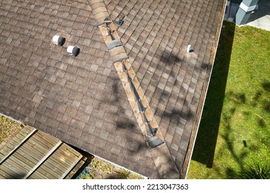 Wind Damaged House Roof With Missing Asphalt Shingles After Hurricane Ian In Florida. Repair Of Home Rooftop Concept