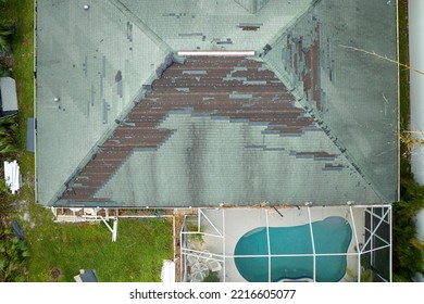 Wind Damaged House Roof With Missing Asphalt Shingles After Hurricane Ian In Florida. Repair Of Home Rooftop Concept