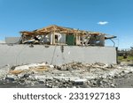 Wind destroyed house roof and walls with missing asphalt shingles after hurricane Ian in Florida. Demolition of building after natural disaster