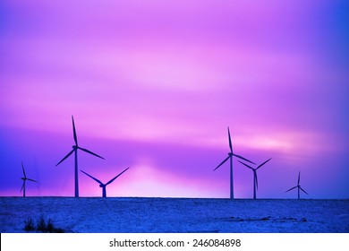 wind driven electric plant in firstlight on snow