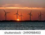 Wind energy. Sun setting behind wind energy farm on Icarai de Amontada beach, CE, Brazil on July 1, 2024.