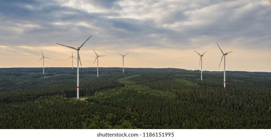 Wind Farm In The Forest At Sunset - Energy Production With Clean And Renewable Energy - Aerial Shot