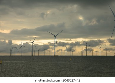 Wind Farm In The Frisian Part Of The IJsselmeer, Near The Dike. The Offshore Wind Farm Is Completely Located In The IJsselmeer, Breezanddijk. Sky With Storm And Rain Clouds. Space For Text.