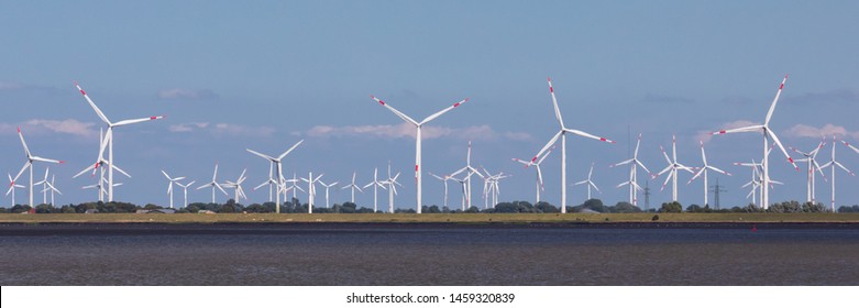 Wind farm with many wind turbines or wind wheels at the North Sea in Dithmarschen, Schleswig-Holstein, Germany. Energy transition.