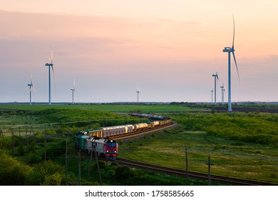 Wind Farm And Moving Train At Sunset