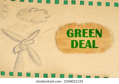A wind generator and clouds are drawn on cardboard with green holes, next to it lies a cardboard with the inscription - Green Deal. Ecological concept.