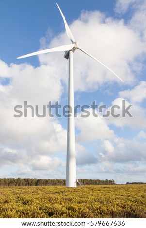 Wind generator in the field on a background beautiful clouds