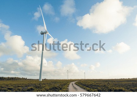 Wind generators in the field on a background beautiful clouds
