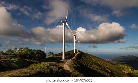 Wind Generators, Road To Energy Transition On A Hill And A Background Of Clouds