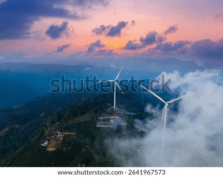 Wind generators with sunset and clouds on tea hills, industry landscape. Aerial view Turbines for renewable electric power production.