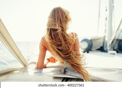 wind in hair yachting girl yachting on sailboat. Back view