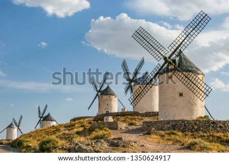 Wind mills at knolls at Consuegra, Toledo region, Castilla La Mancha, Spain. Route of Don Quixote with windmills. Summer landscape with blue sky and clouds