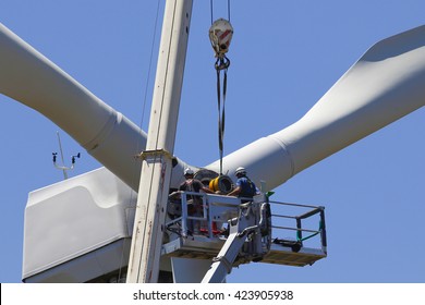 Wind turbine being repaired, assisted by crane and elevator