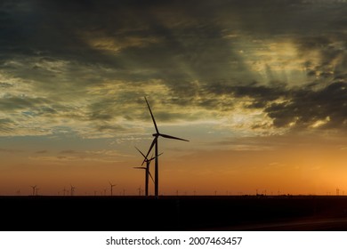 Wind turbine farms in the colorful sunset showing renewable energy works, wind energy blows into West Texas