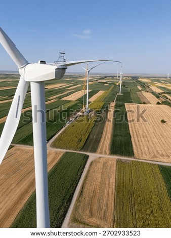 Wind turbine installation using a large construction crane. The assembly process of the turbine tower and rotor blades	