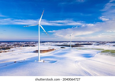 Wind turbine on snowy field. Alternative energy in winter. Aerial view of nature in Poland, Europe