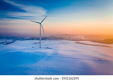 Wind turbine and snowy field in winter. Alternative energy in Poland. Aerial view nature in Poland