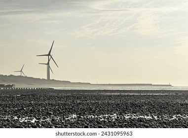 WIND TURBINE wind-mill generator; wind-driven at pebbleand sand beach