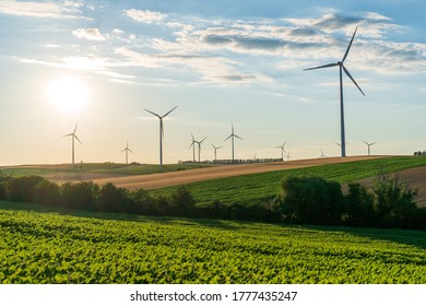 Wind turbines and agricultural field on a summer sunset day. Energy production, clean and renewable energy. - Powered by Shutterstock